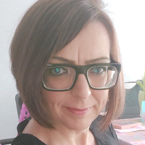 Porträt von Claudia Bartsch mit braunen Haaren, Brille und einem freundlichen Gesichtsausdruck.