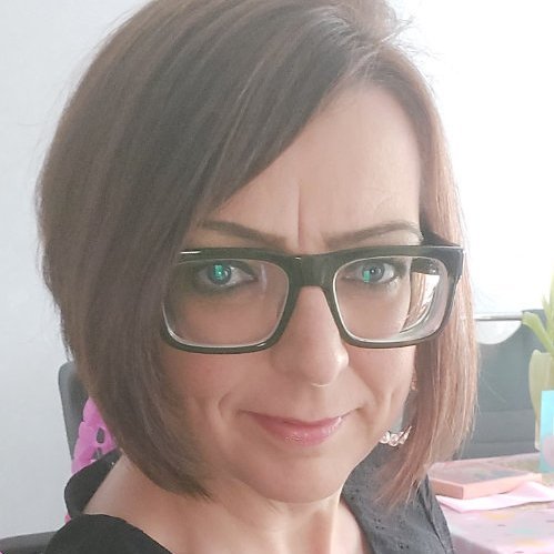 Porträt von Claudia Bartsch mit braunen Haaren, Brille und einem freundlichen Gesichtsausdruck.
