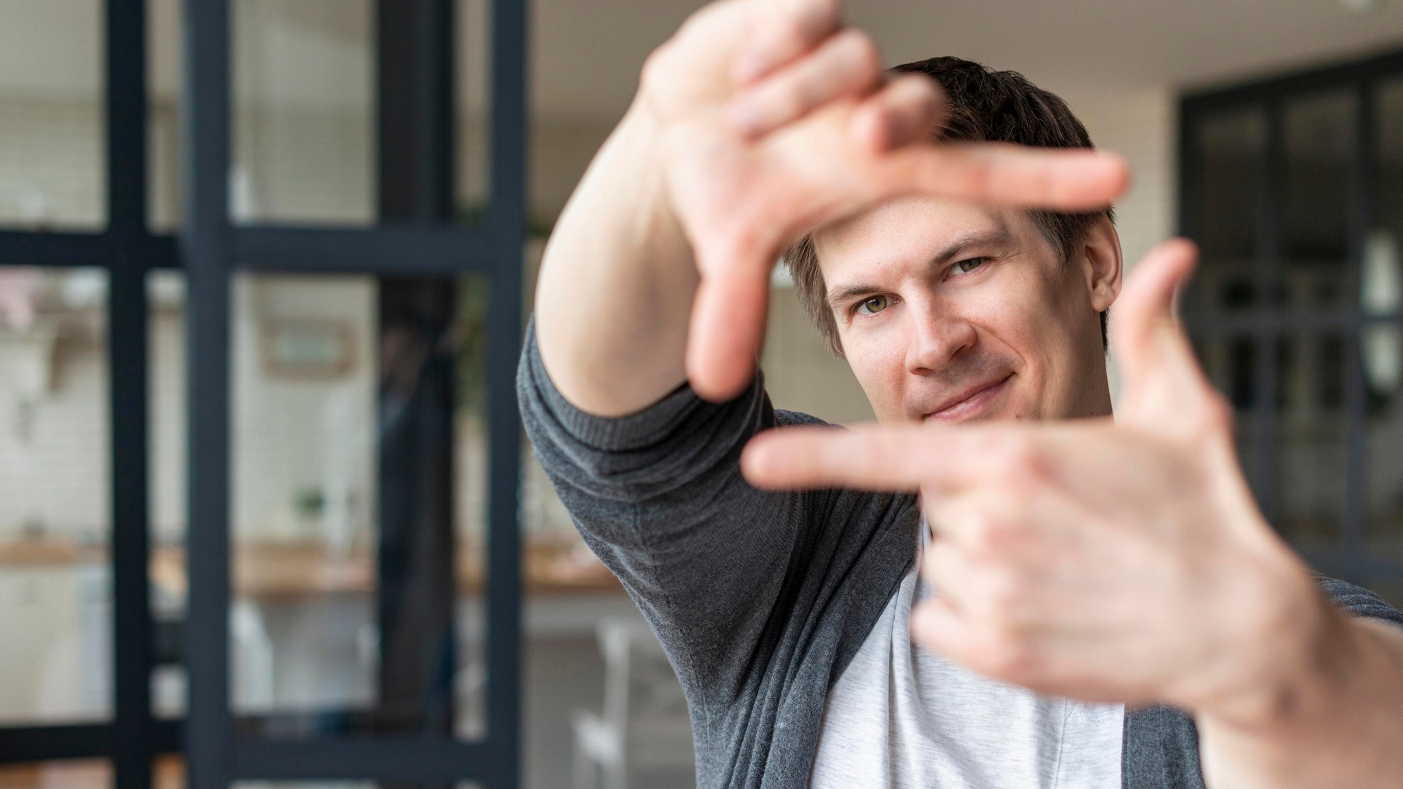 Ein Mann, der mit seinen Fingern ein Fenster bildet um den Fokus auf sich selbst zu richten